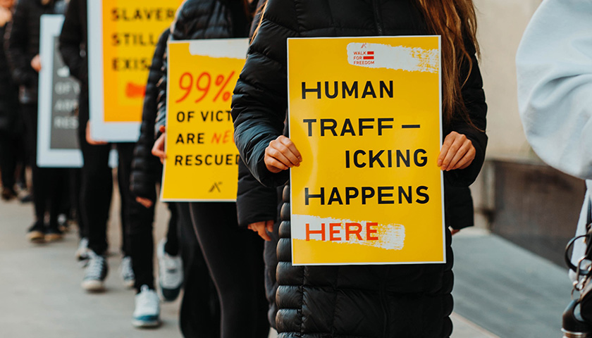 Group of protestors holding human trafficking signs
