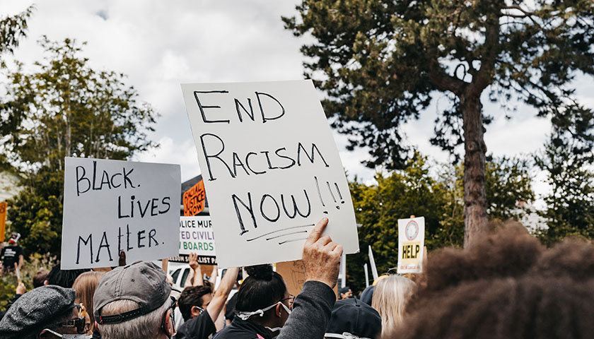 "End Racism Now" sign and "Black Lives Matter" in a crowd