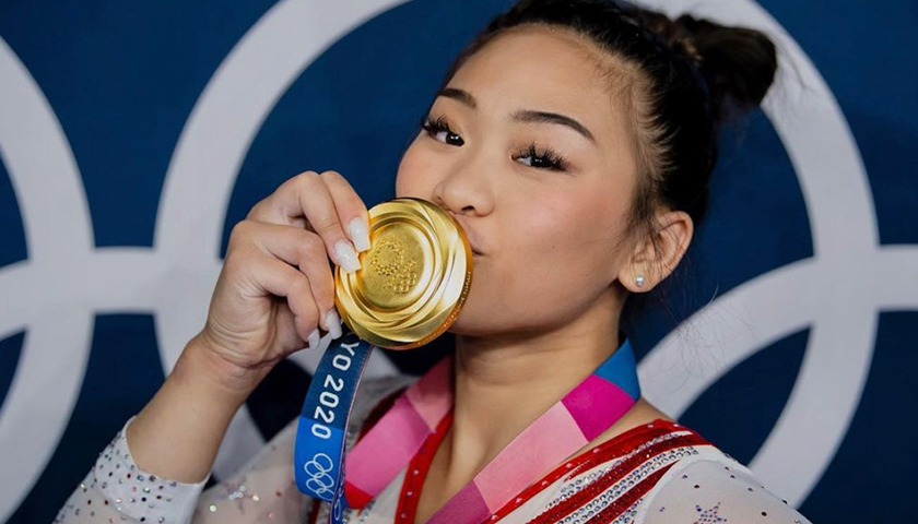 Suni Lee kissing her gold medal