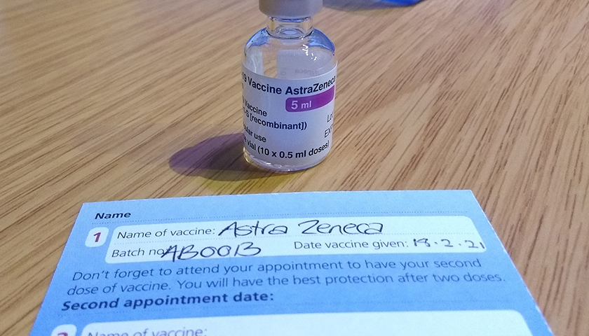 COVID-19 AstraZeneca Vaccine vial and NHS record card