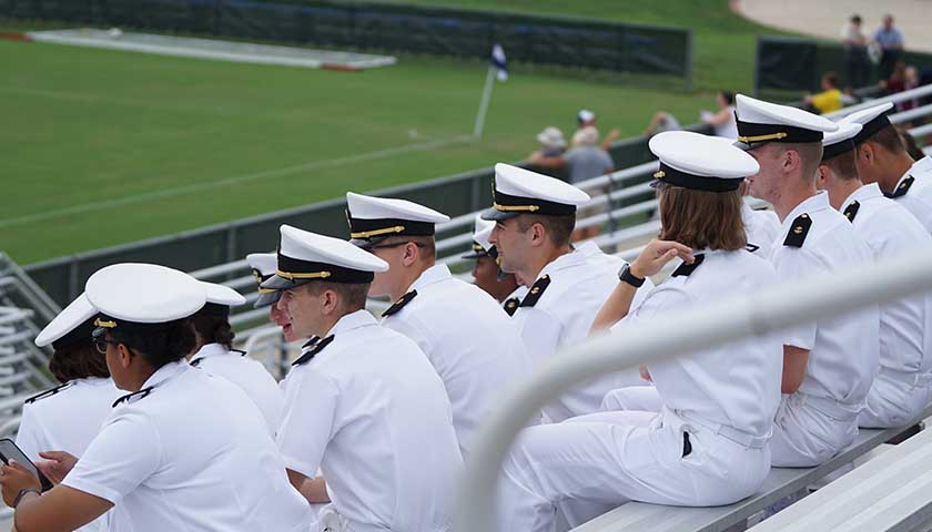 group of Navy members sitting on bleachers
