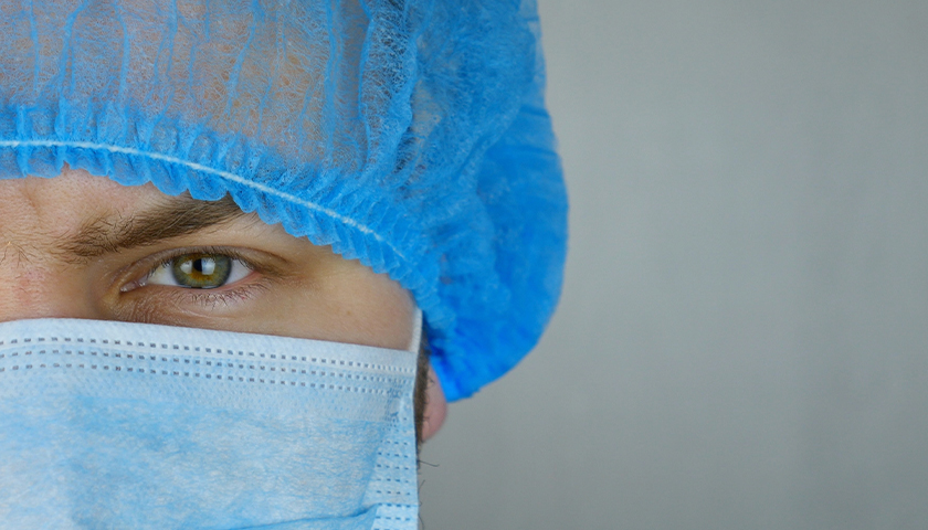 Healthcare worker in hair net and mask on